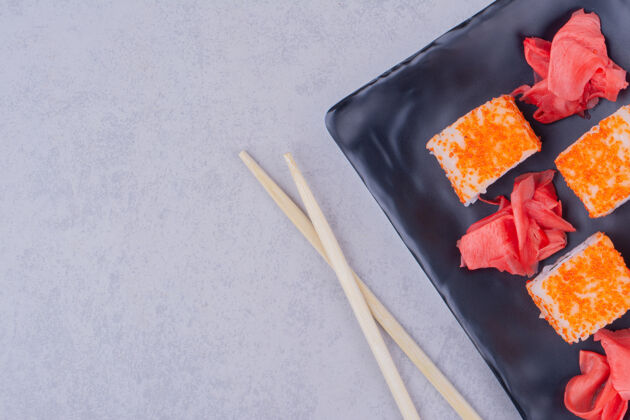 午餐费城三文鱼卷和红姜放在陶瓷盘子上产品亚洲日语