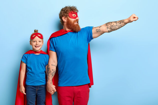 红发家庭权力概念自信开朗的父亲和小女儿假装超级英雄女儿勇气服装