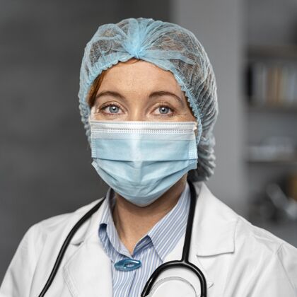 医生戴着医用面罩和发网的女医生的正面图职业面罩卫生工作者