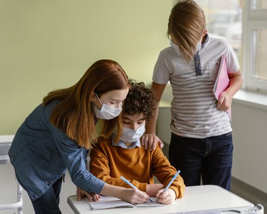 新常态戴着医用口罩的孩子在学校学习学生冠状病毒课堂