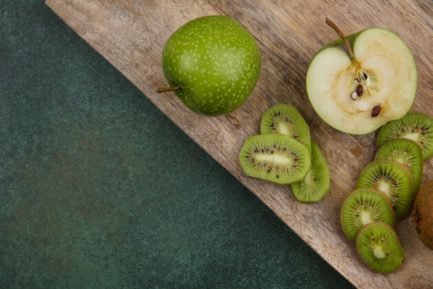 切片顶视图绿色背景上黑板上的绿色苹果和猕猴桃片猕猴桃苹果食物