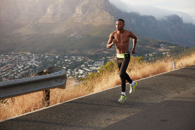 活动体格健壮的男子在户外公路上跑步 长途跋涉 为马拉松做准备体格健壮的男子下山锻炼 穿着运动鞋 紧身裤 身体健康运动运动员肌肉