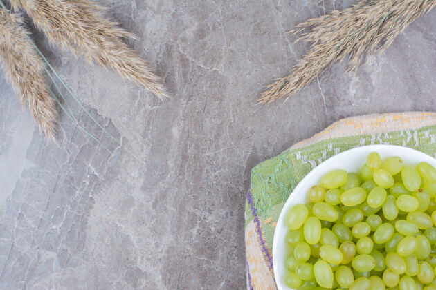绿色一碗绿葡萄放在五颜六色的桌布上新鲜自然植物