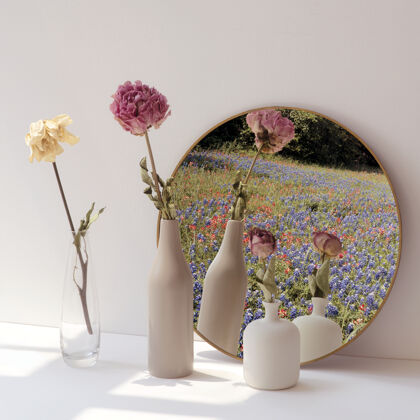 镜子把干花放在最小的花瓶里 放在圆镜子旁边托盘树叶装饰