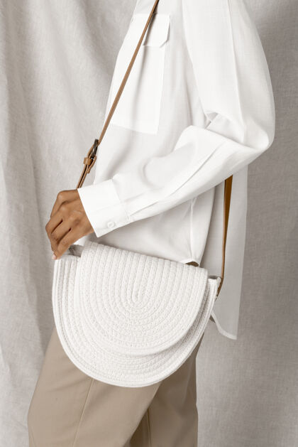 朴素一个黑色的女人拿着一个白色的编织棉绳袋模型皮带携带手工制作