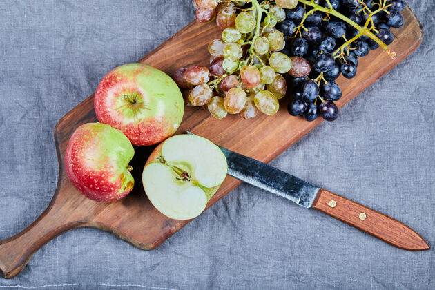 新鲜在木板上放着绿葡萄和红葡萄的苹果蔬菜异国情调素食