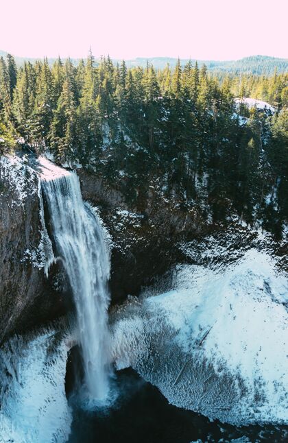 石头一个美丽的瀑布和森林在冬天的垂直镜头环境岩石树