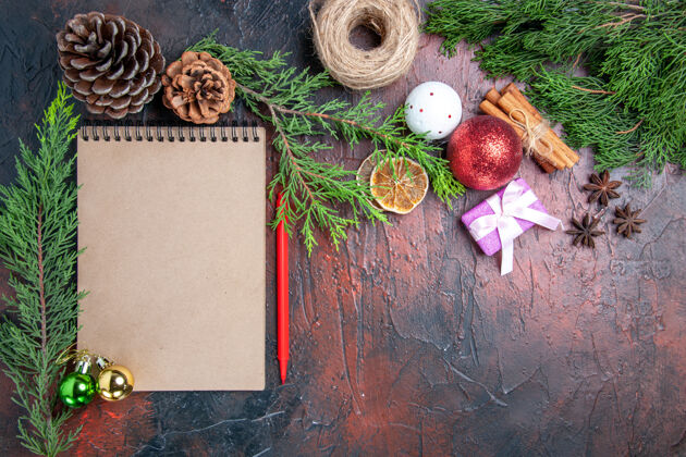 稻草顶视图红笔笔记本松树枝圣诞树球玩具和礼品桂圆八角草线暗红色表面自由的地方线圣诞节地方