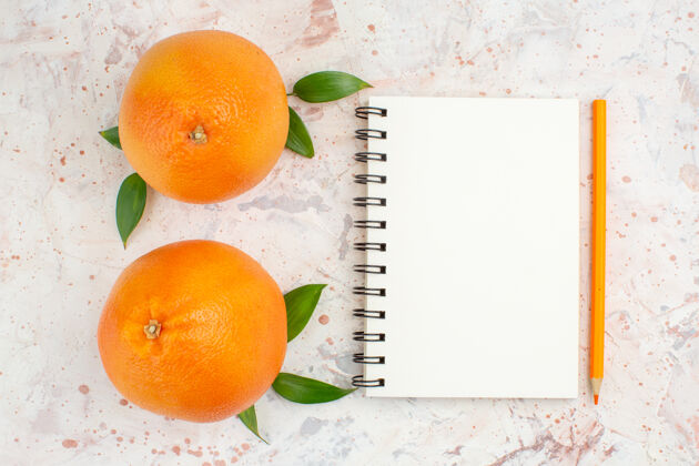 观点顶视图新鲜橙子笔记本橙色铅笔明亮的孤立表面铅笔顶部新鲜的橙子
