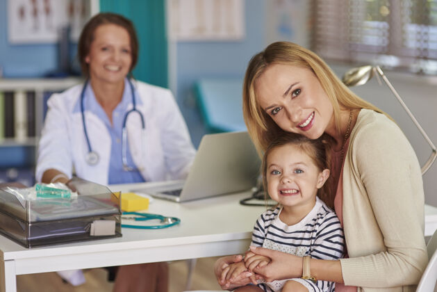 坐姿妈妈和女儿去看医生通信学龄前儿童检查