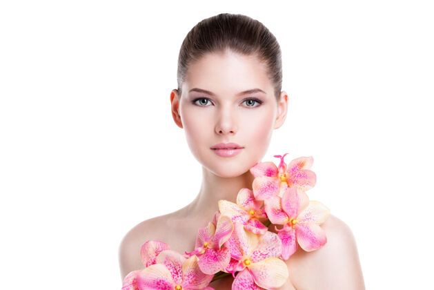 性感美丽的年轻女子的肖像 健康的皮肤和粉红色的花朵在身体上-隔离在白色干净脸触摸