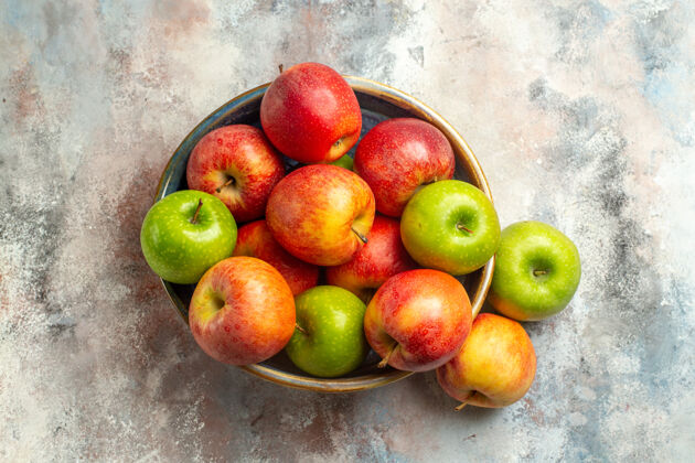 视图顶视图红色和绿色的苹果碗在裸体表面与复制的地方吃苹果油桃多汁
