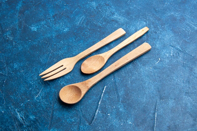 叉子底部视图木制叉子勺刀蓝色表面与自由空间晚餐午餐勺子