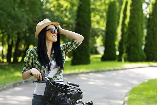 健康的生活方式骑自行车的快乐年轻女子快乐帽子快乐