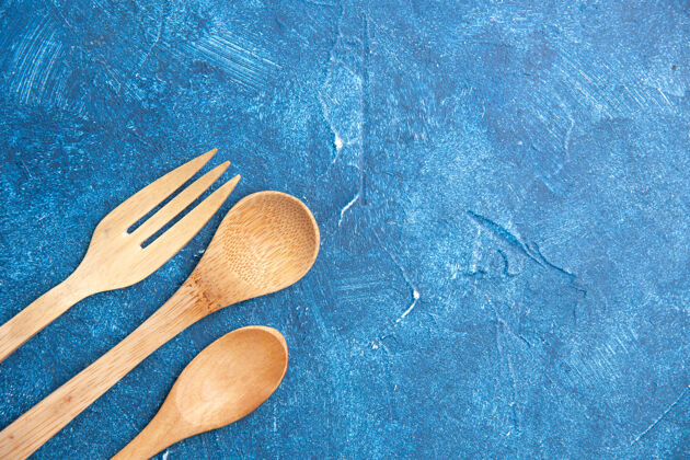 刀顶视图木制刀叉勺子放在蓝色桌子上自由活动地方叉子厨房