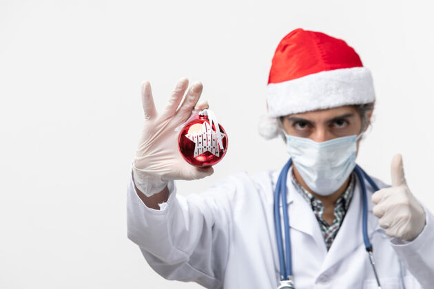 病毒正面图男医生戴着口罩和玩具上白墙病毒冠状病毒健康过年诊所成人圣诞节