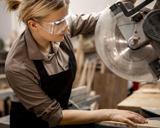 女性带工具和护目镜的女木匠侧视图妇女工作就业