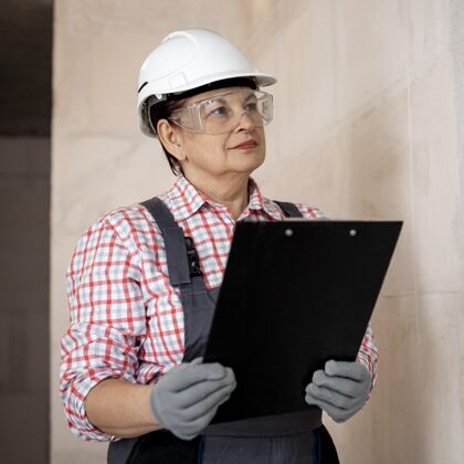 妇女带着头盔和剪贴板的女建筑工人职业帽子职业