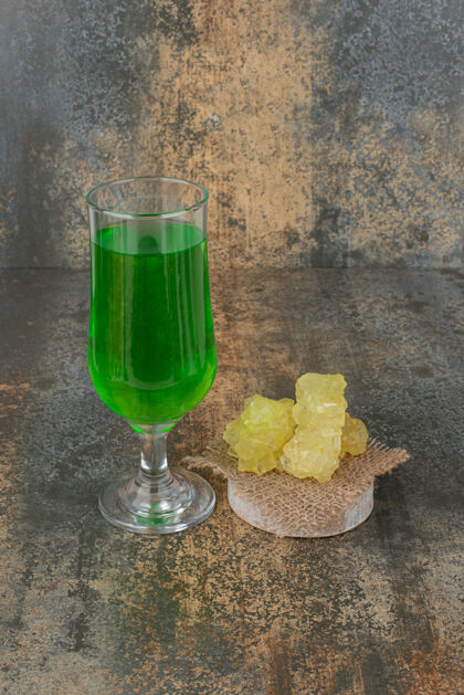 粗麻布在大理石墙上放一杯绿柠檬水和几片黄糖大理石杯子果汁