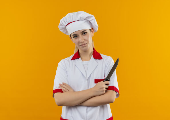 漂亮年轻漂亮的厨师穿着厨师制服隔离在橙色的空间P厨师制服