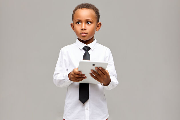 游戏学习 教育 科技和通讯理念帅气聪明的非洲学生穿着校服 用数字触摸板摆姿势 使用无线互联网连接领带现代年轻