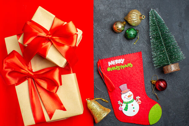 袜子俯视美丽的礼物与蝴蝶结形丝带旁边的杉树枝装饰配件圣诞袜上的红色背景树枝上衣冷杉