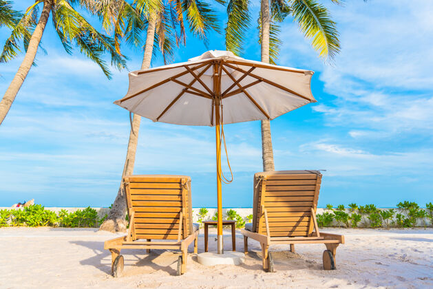 休闲酒店度假区的户外游泳池周围有雨伞和躺椅 有海边沙滩和椰子树甲板景观海洋