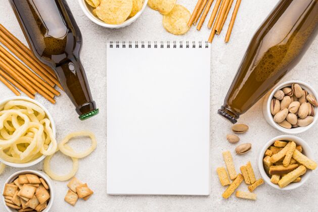 平板笔记本的顶视图 里面有各种各样的零食和啤酒瓶俯视图酿造麦芽酒