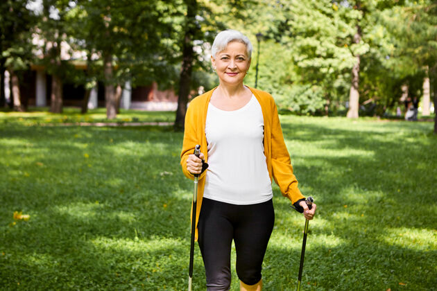 公园活动 幸福 运动和退休的概念迷人的适合老年女性在时尚的自行车短裤和开衫摆出户外与特别棒 享受斯堪的纳维亚人在公园散步森林女人活力