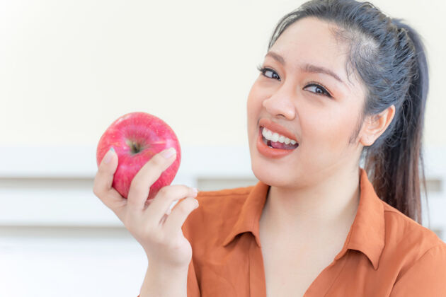 糖果超重的亚洲丰满女性与苹果腹部健康苹果