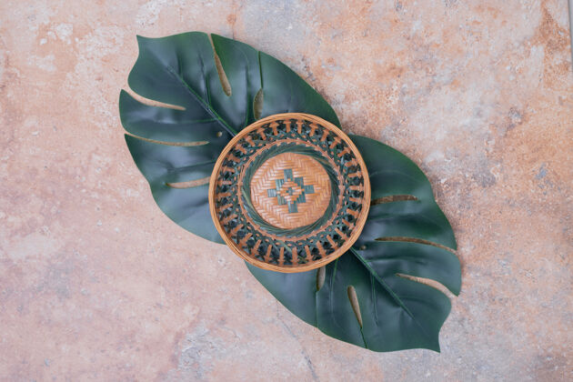 植物大理石表面的陶瓷碗和人造树叶叶人造碗