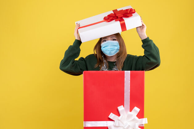 年轻正面图年轻女性在无菌口罩礼品盒内与礼物年轻女性礼物圣诞节