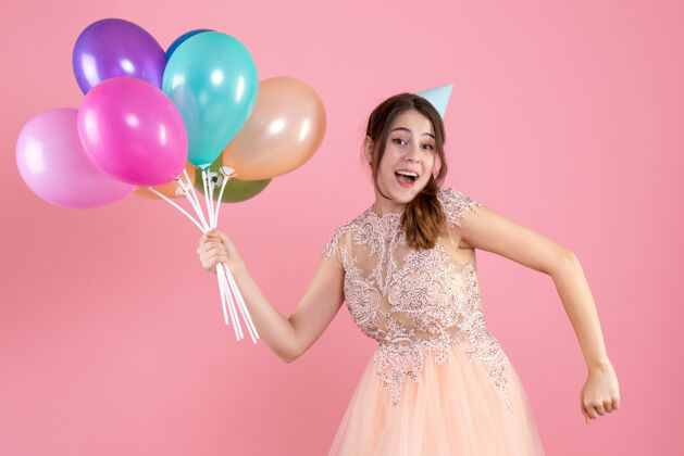 贵族戴着派对帽的派对女孩拿着气球 穿着粉红色的衣服跑步聚会女孩可爱粉色
