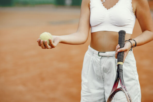 游戏今天玩得很开心 穿着t恤的年轻女子拿着网球拍和球的女子运动球活跃