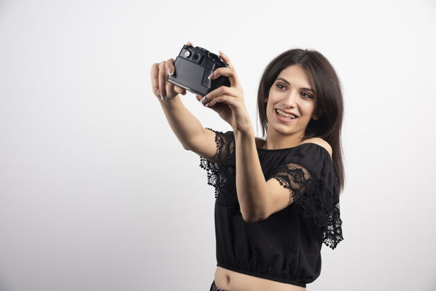 肖像黑发女人用相机自拍摄影师焦点看