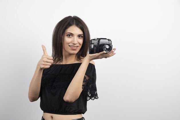 焦点漂亮女人拿着相机竖起大拇指人相机相机