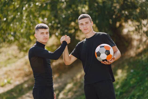 活动男子在公园玩足球迷你足球锦标赛穿黑色运动套装的家伙球员户外足球