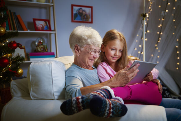 互联网现代祖母和祖父使用平板电脑家庭生活微笑