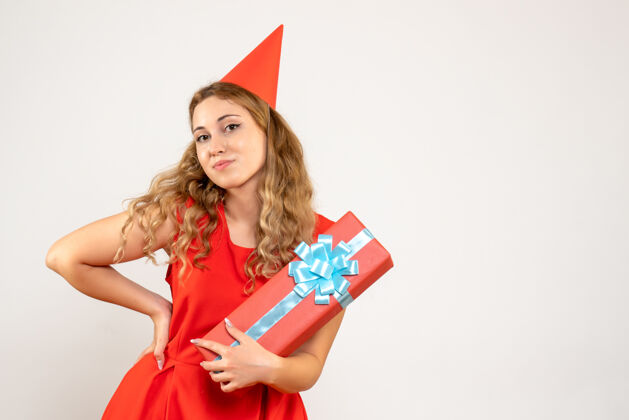 颜色正面图身着红色连衣裙的年轻女性用礼物庆祝圣诞节人物年轻女性女性