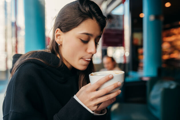 美丽美女喝咖啡的特写照片一位女士手拿一个白色的杯子女人休闲人