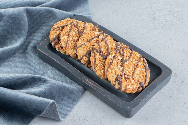 烘焙把饼干包放在木板上 靠近大理石背景上的桌布糖美味烘焙食品