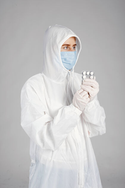 医生戴着医用面罩的医生冠状病毒主题隔离在白墙上带着药片的女人临床制服专家