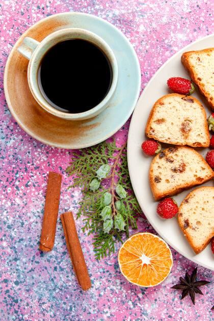 生的顶视图蛋糕片与新鲜的红色草莓和咖啡杯粉红色表面蛋糕烤甜饼干颜色派糖饼干咖啡早餐饼干