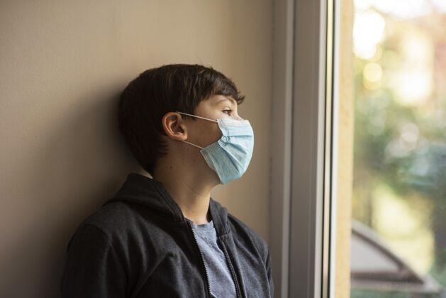 冠状病毒侧视图戴着医用面罩的小男孩看着别处预防流感青少年