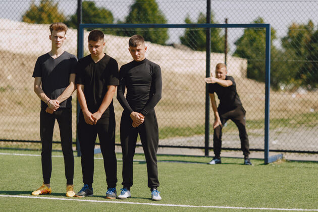 足球男子在公园玩足球迷你足球锦标赛穿黑色运动套装的家伙运动户外健身