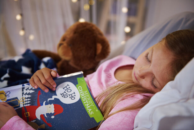 晚上带着书和泰迪熊小睡的小女孩睡觉家部分