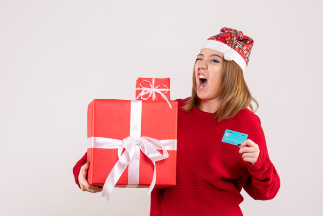女人前视图年轻女性 带着小圣诞礼物和银行卡卡片小丝带