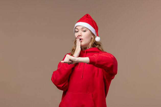 歌手前视图圣诞节女孩检查时间上的棕色背景节日圣诞节情绪圣诞节背景棕色