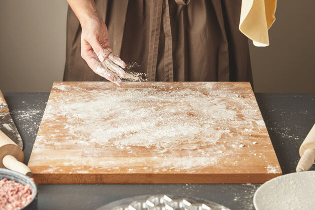 意大利乳清饭面目全非的女人在木板上加了些白面 手里拿着平面团在空中做意大利面或饺子馄饨烹饪一步一步指导肉美味烹饪