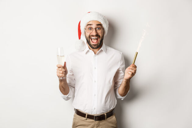 胡须寒假和庆祝活动戴着圣诞帽的快乐的家伙在新年派对上欢呼雀跃 喝着香槟 高喊着快乐快乐兴奋红色